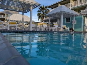 a swimming pool at a resort with chairs and condos at Seashell Village Resort near the beach with kitchens in Port Aransas