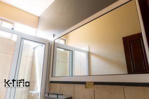 a bathroom with a large mirror on the wall at Cómodo y Seguro in Catacamas