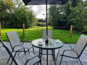 einen Tisch und Stühle mit Sonnenschirm auf einer Terrasse in der Unterkunft Corradiller Quay, Lisnaskea, Fermanagh in Lisnaskea