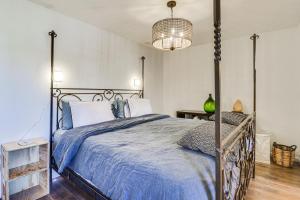 a bedroom with a metal bed with a blue comforter at Eclectic Stone Cottage, Walk to Downtown Staunton! in Staunton