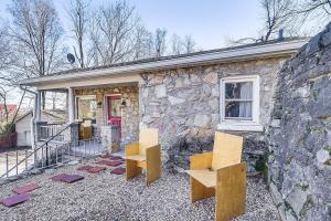 two wooden benches sitting outside of a stone building at Eclectic Stone Cottage, Walk to Downtown Staunton! in Staunton