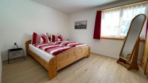 a bedroom with a bed with red pillows and a window at Ferienwohnung mit idyllischer Aussicht in Klosters