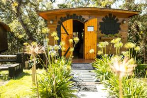 un cobertizo de madera con una puerta en un jardín en Pousada Chales da Mantiqueira - Campos do Jordão, en Campos do Jordão