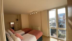 two beds in a room with a large window at Free parking near city centre & stadium sleeps 6-8 in Leicester