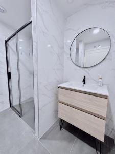 uma casa de banho branca com um lavatório e um espelho em Apartamento Domus em Teruel