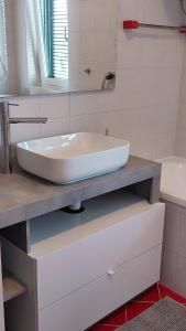 lavabo blanco en la encimera del baño en NAT Apartments, en Koper