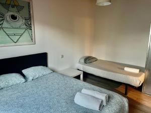 - une petite chambre avec 2 lits et un miroir dans l'établissement Apartamentos Gran Via Musicales, à Madrid