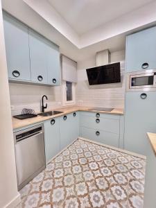 una cocina con armarios blancos y fregadero en Apartamento Domus, en Teruel