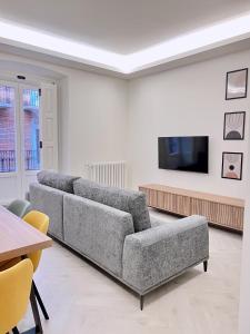 uma sala de estar com um sofá e uma televisão de ecrã plano em Apartamento Domus em Teruel