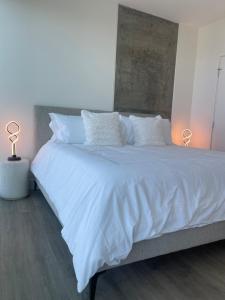 a large bed with white sheets and pillows at Extraordinary Escape with Rooftop Pool 2 in San Diego