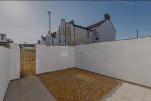 una cerca blanca con una puerta y algunas casas en The Residency rooms Liverpool en Wallasey