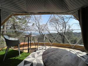 a room with a table and chairs and a large window at Glamping Dome 1 - 10 minutes from Kings Canyon in Dunlap