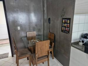 einen Esstisch mit 2 Stühlen und einem Glastisch in der Unterkunft Apartamento inteiro em condomínio in Rio Branco