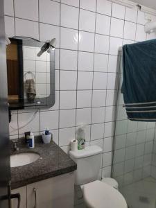 a bathroom with a toilet and a sink and a mirror at Apartamento inteiro em condomínio in Rio Branco