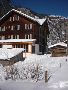 a building with snow on the ground in front of it at Alpenhof Mountain Lodge in Stechelberg