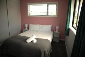 um quarto com uma cama com duas toalhas brancas em Sunset Views em Kaikoura