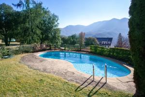 una piscina en un patio con montañas al fondo en Casa con vistas al Parque Natural del Montseny, en Viladrau