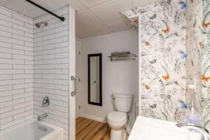 a bathroom with a toilet and a sink and a tub at Cozy Private Apt near Downtown in Burlington +2 photos