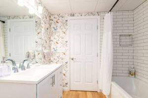 Łazienka z białymi drzwiami, wanną i umywalką w obiekcie Cozy Private Apt near Downtown w mieście Burlington