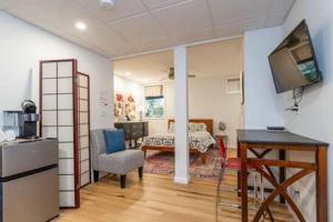 a room with a kitchen and a living room with a television at Cozy Private Apt near Downtown in Burlington