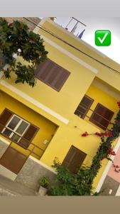 a yellow house with windows and plants in front of it at Constança Retreat in Mindelo