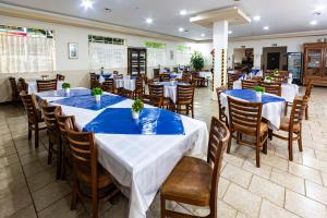 a restaurant with tables and chairs with blue tablecloths at Hotel Excelsior in Poços de Caldas