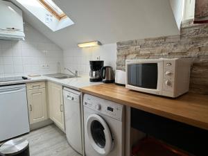 a kitchen with a microwave and a washer and dryer at Charmant duplex pour 2/3 pers in Cauterets