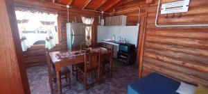 a small kitchen with a table and a refrigerator at Cabañas Angualasto in Uspallata