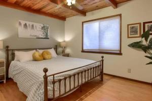 1 dormitorio con 1 cama con 2 almohadas en Red Door Cottage Fireplace bbq 12 mi to Yosemite en Oakhurst