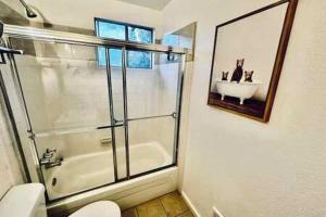 a bathroom with a shower and a toilet and a sink at Red Door Cottage Fireplace bbq 12 mi to Yosemite in Oakhurst +17 photos