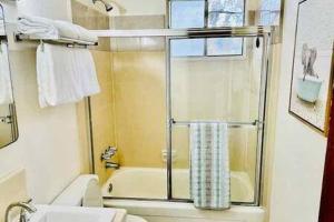 a bathroom with a shower and a toilet and a sink at Blue Door Cottage 12 miles to Yosemite Bbq in Oakhurst +19 photos