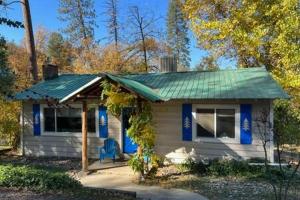 a small white house with a green roof at Blue Door Cottage 12 miles to Yosemite Bbq in Oakhurst