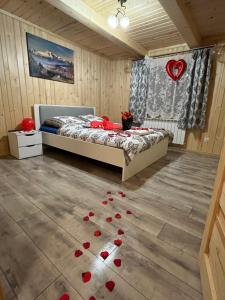 a bedroom with a bed and red roses on the floor at Chata na Grapie in Biały Dunajec