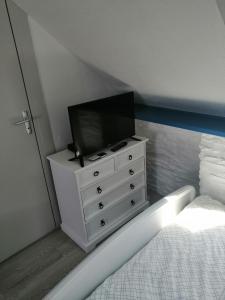 ein Schlafzimmer mit einer Kommode mit einem Fernseher drauf in der Unterkunft Studio 1 proche du port in Cancale