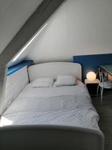 ein weißes Bett mit zwei Kissen in einem Zimmer in der Unterkunft Studio 1 proche du port in Cancale