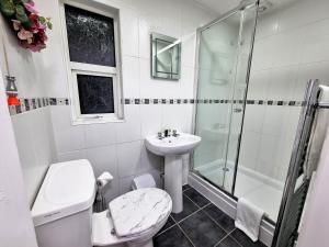 y baño con aseo, lavabo y ducha. en *RA1GH* For your most relaxed & Cosy stay + Free Parking + Free Fast WiFi *, en Bramley