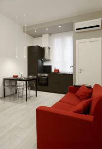 a living room with a red couch and a kitchen at Casa Fiorella in La Spezia