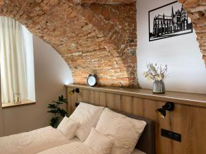 a bedroom with a bed and a brick wall at UnderStreet studio with private parking in Košice