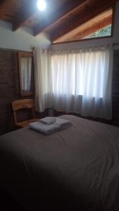 a bedroom with a large bed with a window at Espacio Aquarel Patagonia in Los Repollos