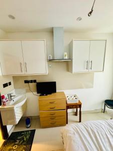 a bedroom with a sink and a bed and a desk at The Great Falcon Accommodation in London