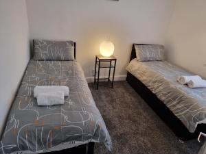 zwei nebeneinander stehende Betten in einem Schlafzimmer in der Unterkunft Dulverton house - 3 bed house /sleeps 6+ driveway+close to M1 in Nottingham