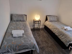 two beds sitting next to each other in a bedroom at Dulverton house - 3 bed house /sleeps 6+ driveway+close to M1 in Nottingham