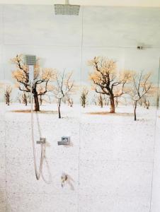 una ducha con nieve en el suelo y árboles en The White House, en Weligama