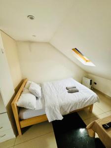 a small bedroom with a bed with white sheets at The Great Falcon Accommodation in London