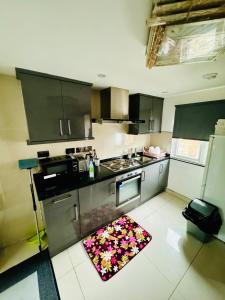a kitchen with stainless steel appliances and a rug on the floor at The Great Falcon Accommodation in London