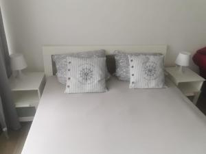 uma cama branca com duas almofadas em cima em Ferienwohnung Küstenkind em Wendtorf