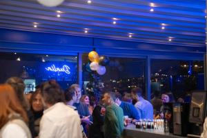 a group of people standing at a bar with balloons at Dunlin Hotel in Athens