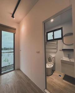 łazienka z toaletą, umywalką i oknem w obiekcie 嵐羽蒔光 w mieście Yuanshan