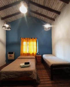 ein Schlafzimmer mit 2 Betten und einer blauen Wand in der Unterkunft Familia Albahaca in Tilcara