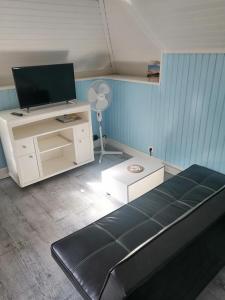 ein Wohnzimmer mit einem Sofa und einem TV in der Unterkunft Studio 2 proche du port in Cancale